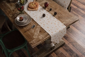 Close-up of beige table runner with golden snowflakes on a rustic wooden table