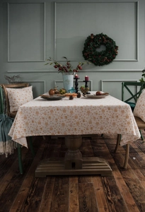 Detail of cream festive tablecloth with gold snowflake patterns and matching pillow case