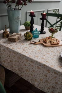 Close-up of festive linen tablecloth featuring golden snowflakes and Christmas patterns