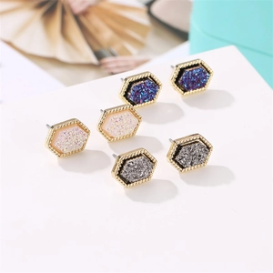 Three pairs of geometric hexagonal stud earrings in blue pink and grey glitter finish