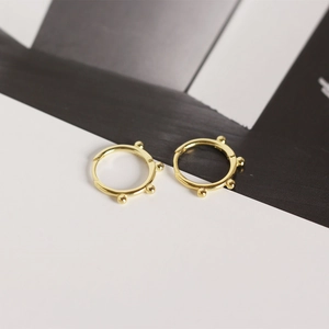 Detailed view of gold S925 sterling silver hoop earrings with small bead decorations