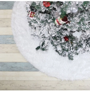 Détail de la jupe de sapin de Noël en fausse fourrure blanche sur sol en bois