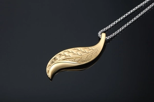 Detailed close-up of golden leaf pendant with realistic vein texture on a silver chain