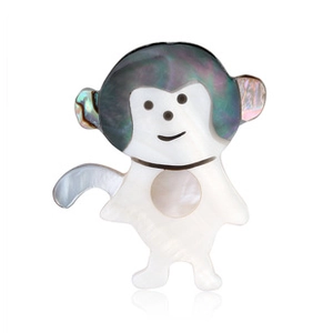 Macro shot of monkey animal brooch crafted from white and grey mother of pearl