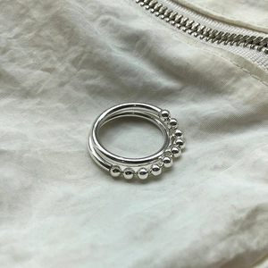 Detailed view of 925 sterling silver beaded rings on a white textured background