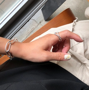 Close-up of minimalist 925 silver beaded ring and chain bracelet on model hand