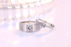 Detail view of silver couple rings with six-prong diamond setting and pattern