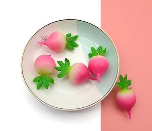 Close-up of five realistic pink and green gradient radish pendants with metal split rings