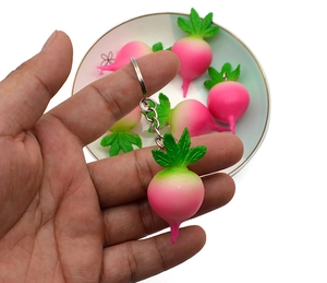 Macro detail of realistic PVC radish keychain with green leaves and metal keyring