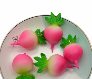 Detailed view of 5 mini radish pendants in pink gradient on a white ceramic plate