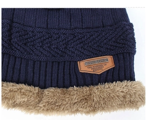 Detail of the navy blue knit beanie showing thick khaki fleece lining and cable knit texture