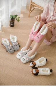 Close-up of thick coral fleece floor socks with cute animal designs and white sherpa lining