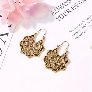 Détail de boucles d'oreilles mandala vintage dorées avec sculpture florale bohème