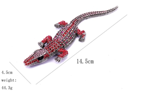 Macro shot of silver crocodile brooch with pink and red rhinestones, 14.5cm length