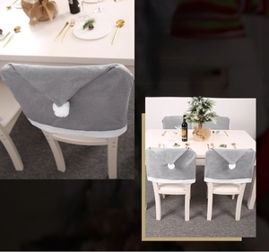 Close-up of grey non-woven Christmas chair cover with white pompom and festive dining setup
