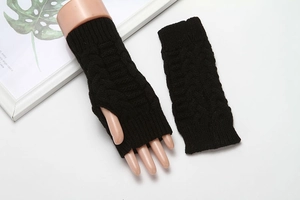 Detail view of black knitted fingerless gloves with soft wool texture on white background