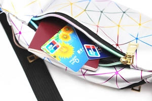 Macro view of multi-layer laser waist bag showing interior storage for passport and cards