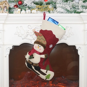 Weihnachtsstrumpf mit Schneemann-Applikation an einem weißen Kamin mit festlicher Deko