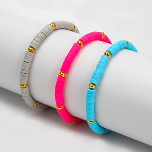 Detailed view of colorful clay bead bracelets in grey, rose red, and sky blue hues
