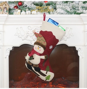 Detail eines Weihnachtsstrumpfs aus Filz mit 3D-Schneemann an einem gemütlichen weißen Kamin