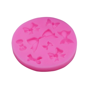 Macro shot of pink silicone mold featuring various bow tie designs for fondant and chocolate