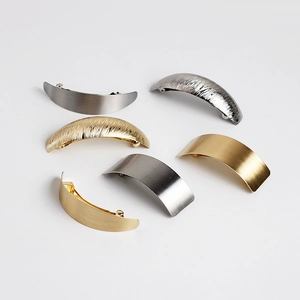 Close-up of minimalist brushed metal hair clips in gold, silver, and gunmetal finishes