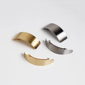 Detail of minimalist brushed metal spring hair clips in gold, silver, and gunmetal finishes