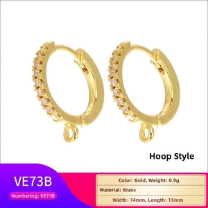 Detailed view of gold brass huggie hoop earrings with cubic zirconia and hanging loop