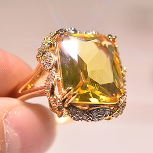 Close-up of champagne square-cut gemstone ring with sparkling small white diamonds
