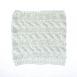 Detail der weißen Zopfstrick-Textur und des weichen Stoffs bei diesem Strickschal
