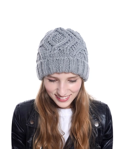 Detail of the chunky diamond knit pattern and ribbed cuff on a gray winter beanie