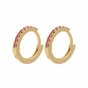 Detailed view of gold-plated hoop earrings with micro-pave red cubic zirconia settings
