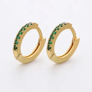 Macro view of gold-plated brass huggie earrings with pave emerald green crystals, 13x14mm size