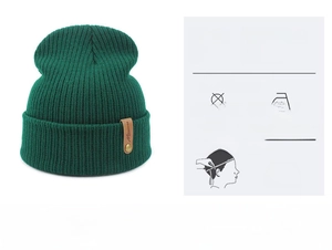 Detail of dark green knit beanie featuring a brown leather patch with gold rivet detail