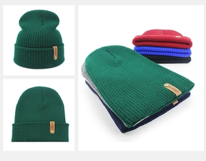 Macro detail of ribbed knit beanie texture with brown leather logo tag and metal rivets