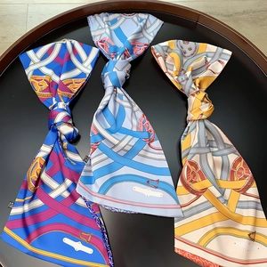 Detailed flat lay of colorful double-layered twill silk scarves with vintage chain patterns
