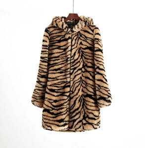Detailed view of luxury tiger stripe faux fur coat texture and soft hood on wooden hanger