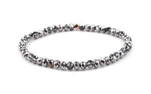 Detail of grey faceted crystal beads and a gold accent bead on an elastic bracelet