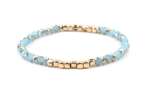Detail of light blue faceted crystal beads and gold metal square spacers on a beaded bracelet