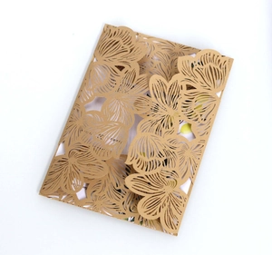 Detailed laser-cut floral pattern on brown wedding invitation envelope against white background