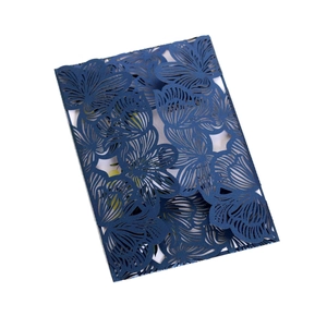 Detail of laser-cut floral pattern on navy blue cardstock for wedding invitations