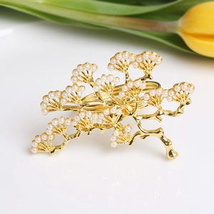 Golden pine branch napkin ring with pearls for wedding table decor on white background