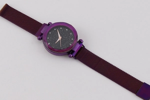Macro shot of purple starry dial watch with faceted glass and magnetic mesh band