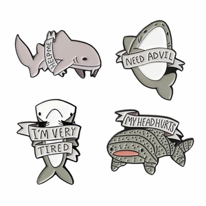 Set of four cartoon shark enamel pins with funny quote ribbons on white background