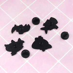 Detail view of cartoon enamel brooch backs with secure black rubber pin clutches