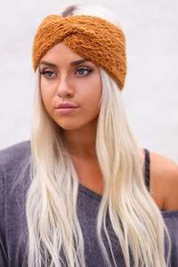 Close-up of ginger yellow chunky knit headband with twist knot texture and warm fabric