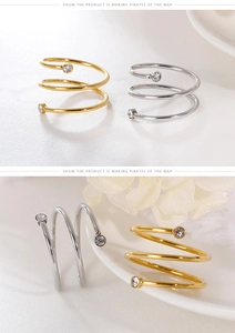 Macro shot of gold and silver spiral rings with sparkling rhinestones on ceramic plate