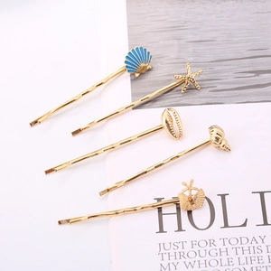Golden shell and starfish hair clips set on a magazine background with ocean elements