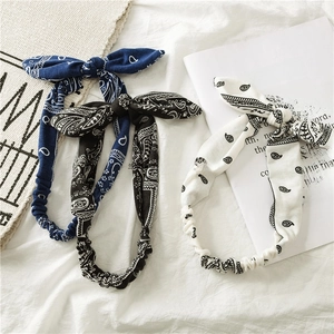 Three-piece set of paisley print elastic headbands with bunny ear bows in blue, black and white