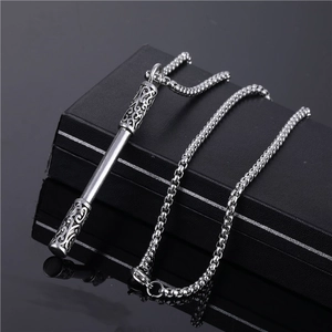 Silver hip hop stainless steel necklace with intricate golden cudgel pendant on a black box
